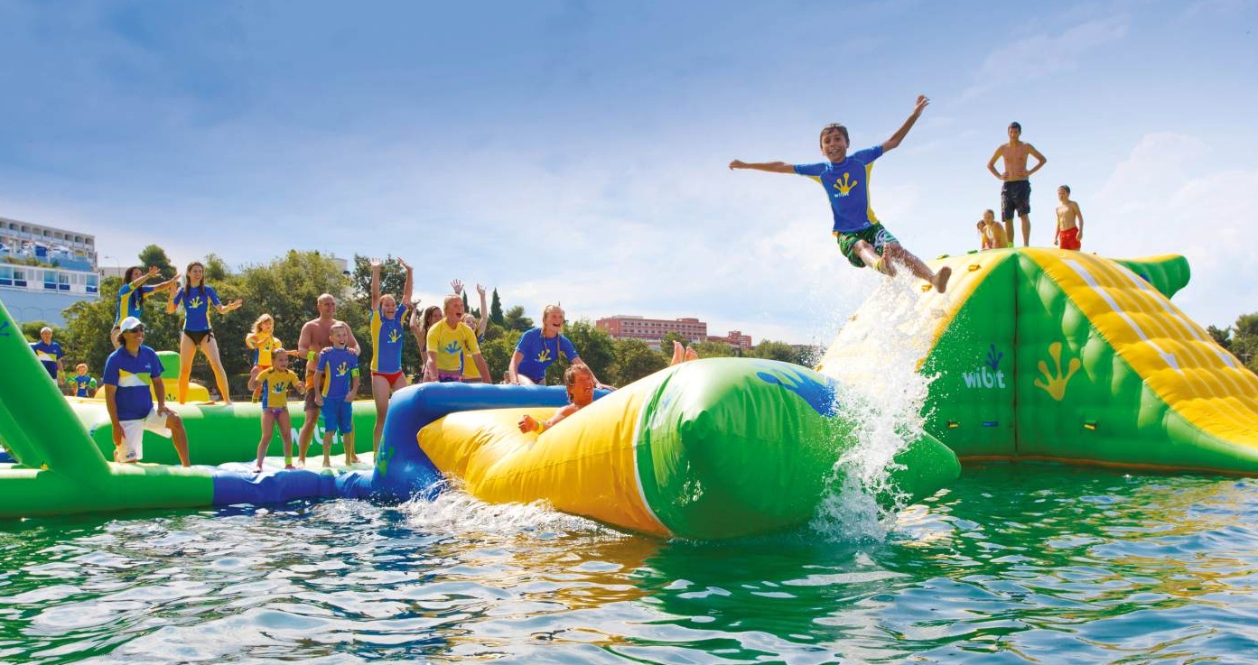 Kids playing on inflatable water obstacle course