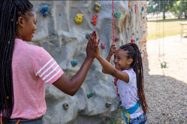 Children learning rock climbing skills with professional instructors